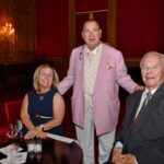 Man in a pink jacket with guests at the June 2025 dinner