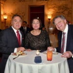 Three guests seated at a cocktail table at the June 2025 dinner