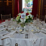 Table 10 set with white linens and a floral centerpiece