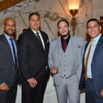 Four men in suits posing at the June 2025 dinner