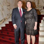 Couple on the red-carpeted staircase at the June 2025 dinner